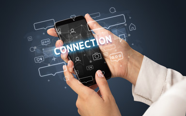 Female hand typing on smartphone with CONNECTION inscription, social media concept