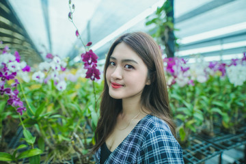 Asian woman in orchid greenhouse