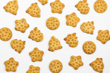 Pattern of Christmas cookies on white background. Different shapes of cookies: Christmas tree, star, bell, circle. Top view, flat lay.