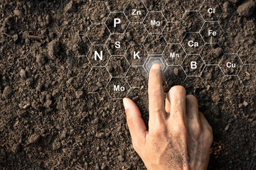 The hands of men are touching on the soil where abundance and technology are icons about the...