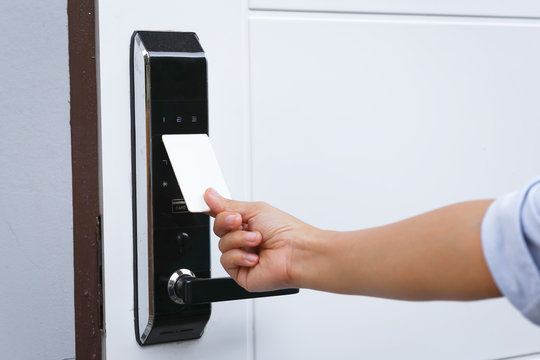 Close-up hand inserting keycard to lock and unlock door - Door access control keypad with keycard reader.