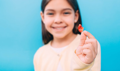 advertising hearing aid for children, a mixed race child shows a hearing aid. Children's hearing treatment