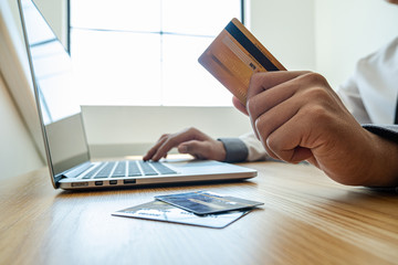 Business men use credit cards and laptops for online shopping and making payments the internet
