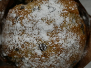 One muffin with chocolate sprinkled with powdered sugar as snow on a white background create a Christmas mood.