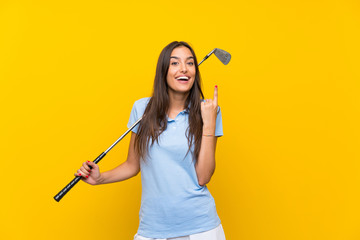 Young golfer woman over isolated yellow wall pointing up a great idea - Powered by Adobe