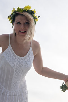 beautiful bride with wedding bouquet standing on a boat and posing for the photographer near the river