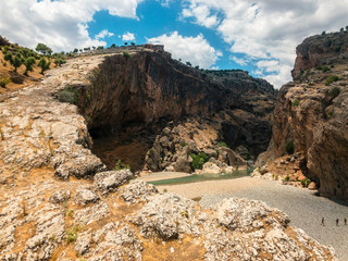 Panoramic view of the gorge with prehistoric caves over the the wide and almost dry river bed of...