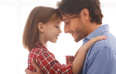 Close up of father and daughter cuddling over white background