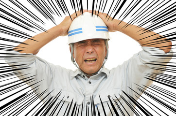 失敗をして頭を抱える男性作業員