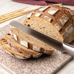 Fresh fragrant bread on a kitchen cutting board made of artificial stone