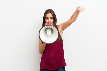 Young woman over isolated white background shouting through a megaphone