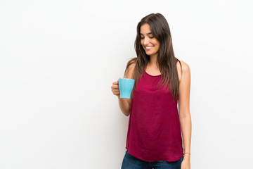 Young woman over isolated white background holding hot cup of coffee