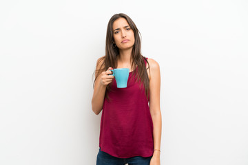 Young woman over isolated white background holding hot cup of coffee