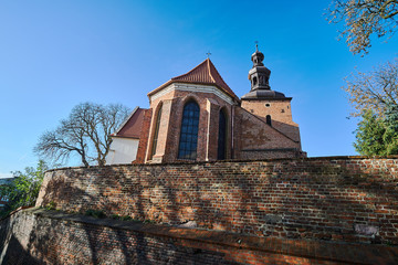 Fototapeta na wymiar medieval wall and the Gothic parish church in Gniezno.