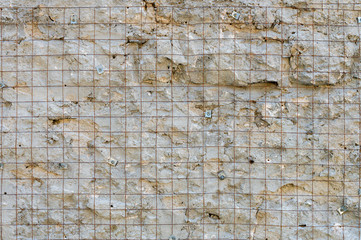 Building background prepared surface of the facade wall of the building with a fixed rusted mesh for cementing and painting the facade. Cement fixing net attached to a rough cement wall
