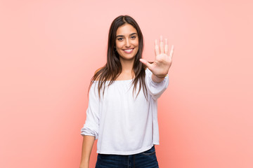 Young woman over isolated pink background counting five with fingers