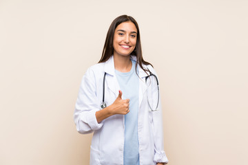 Young doctor woman over isolated background giving a thumbs up gesture