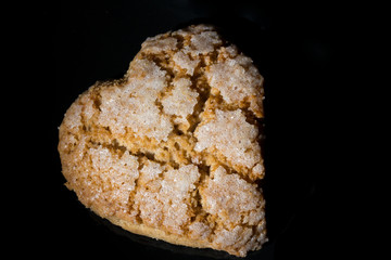 Galletas corazón de canela sobre fondo negro