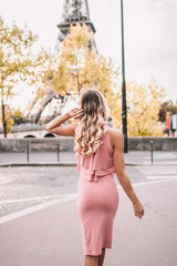 Young woman with pink dress in front of Eiffel tower Paris, France