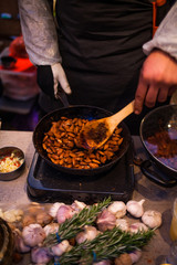 PEANUT FRY WITH COOKING SAND IN A COOKING POT KADAI WITH THE HELP OF A BIG SPOON