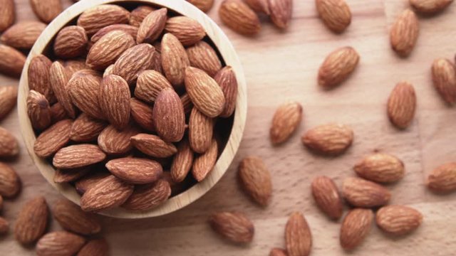 Top view of almond seeds in  bowl wood on table