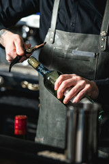 Opening a wine bottle with corkscrew in a bar