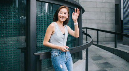 Beautiful good looking Asian woman waving with hand