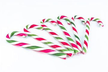 Macro picture of six candy canes in green-red color, isolated on a white background.