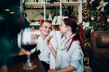 Smiling couple eating pizza on Christmas