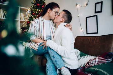 Beautiful couple tenderly kissing on sofa