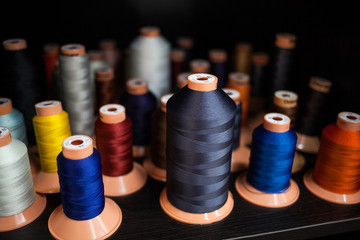 Background of bobbins with multicolored threads for sewing. Needlework, sewing and tailoring...