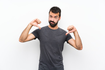 Young handsome man over isolated white background showing thumb down