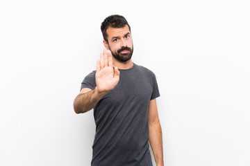 Fototapeta premium Young handsome man over isolated white background making stop gesture