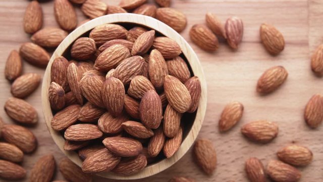 Top view of almond seeds in a wooden bowl	