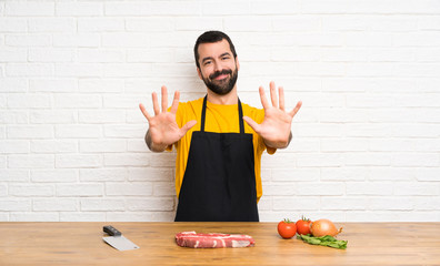 Chef holding in a cuisine counting ten with fingers