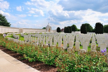 Tyne Cot Commonwealth War Graves Cemetery with rotunda, trees and flowers on a sunny day, outside...