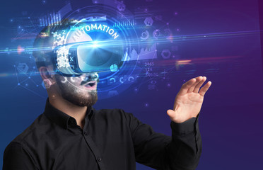 Businessman looking through Virtual Reality glasses with AUTOMATION inscription, innovative technology concept