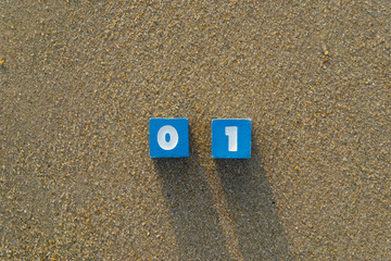 Number zero and one on sand.