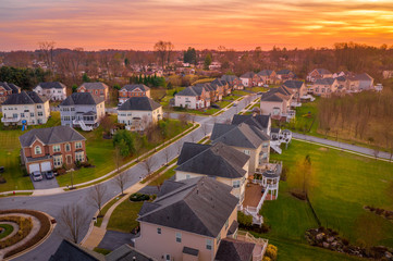 Aerial sunset view of luxury upscale residential neighborhood gated community street in Maryland...