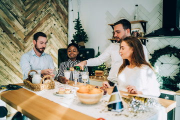 Excited friends pouring champagne at Christmas