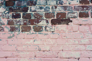 Red brick wall texture background. Old weathered and cracked red bricks with pink paint. Close up