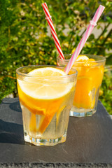 glass of orange juice on wooden background of blue sky