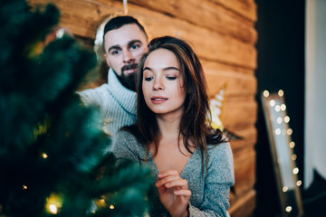 Focused couple decorating Christmas tree