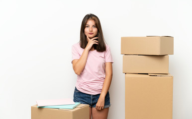 Young girl moving in new home among boxes thinking an idea