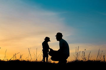 Fototapeta na wymiar silhouette of father and son play on sunset