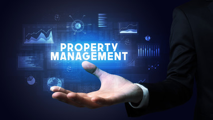 Hand of Businessman holding PROPERTY MANAGEMENT inscription, business success concept