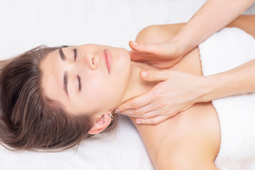 Fototapeta na wymiar massage and stretching of the cervical muscles. Beautiful girl gets massage in a spa salon. light tones photos. concept of massage and health. rheumatism, arthrosis