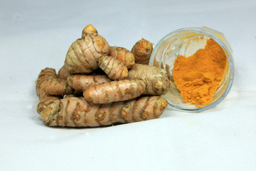 Turmeric root and powder on white background