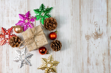 Christmas composition background decoration with gift, christmas ball, and snowflake ornament with pine cone on wooden white background. flat lay, top view, copy space