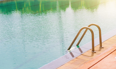 Obraz premium Swimming pool with stair and wooden deck at hotel.